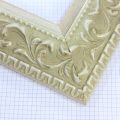 A large, reverse curve profile frame with an intricate leaf design bordered by a geometric outer edge and beaded inner lip.  A White matte base with patina for added depth on the topmost points of the design. Strong, solid wood construction.

3.25 " witdth: ideal for large and oversize (extra large) images.